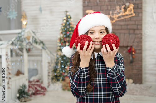 Cheerful kid. Kid santa hat decorating christmas tree. Decorating her favorite activity. Decor shop. Pick decorations home. Child decorating christmas tree balls. Girl kid decorating christmas tree