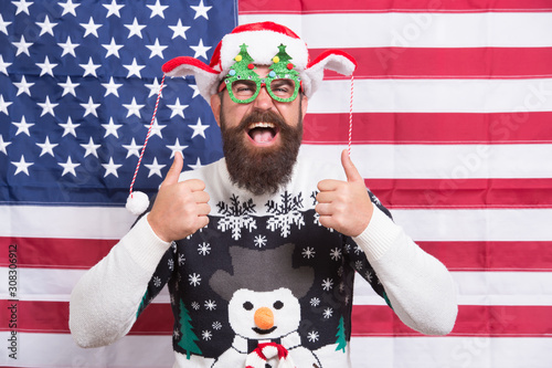 Proud of my country. Winter holidays season. American guy joined cheerful celebration. American tradition. Santa Claus on american flag. Celebrate xmas and new year. Christmas tradition from USA © be free