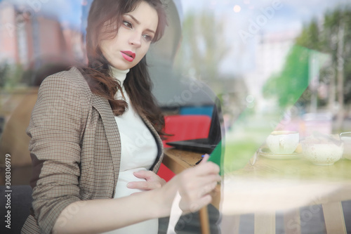 Pregnant woman working on computer in cafe