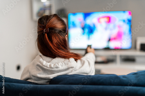 Girl watching tv programs on the sofa photo