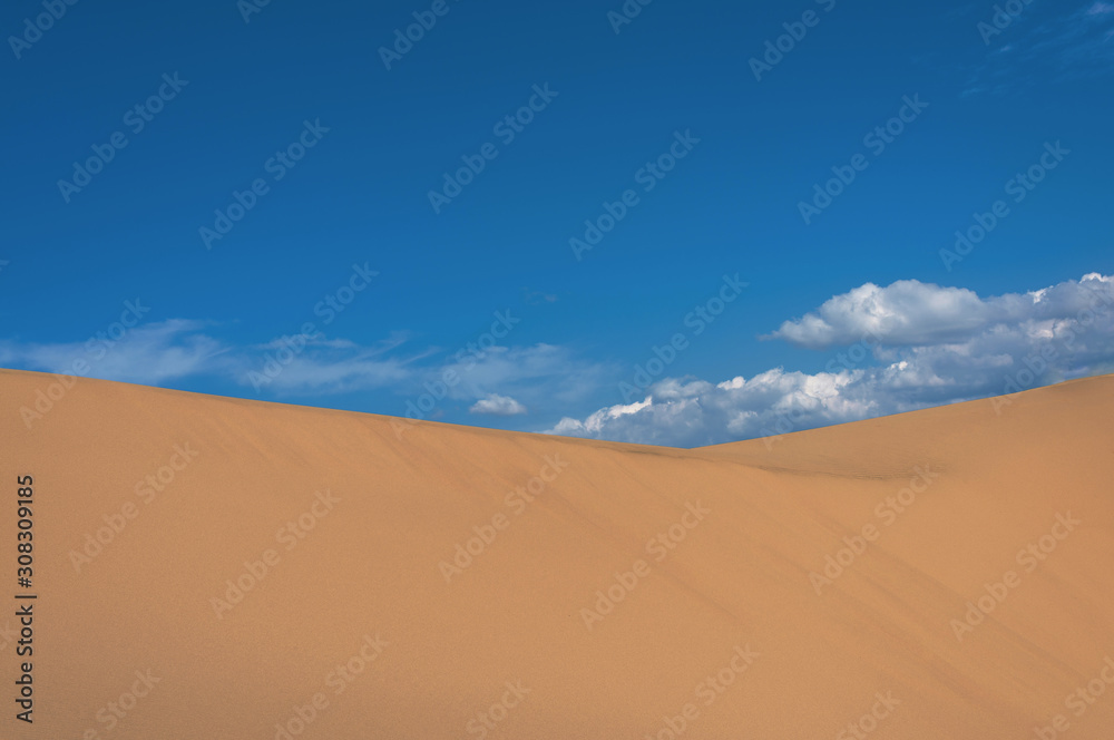 Landscape with sand dune slope and cloudy sky