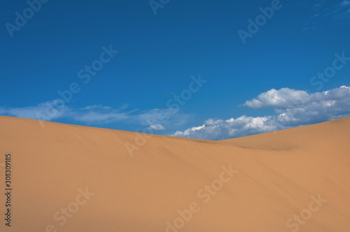 Landscape with sand dune slope and cloudy sky
