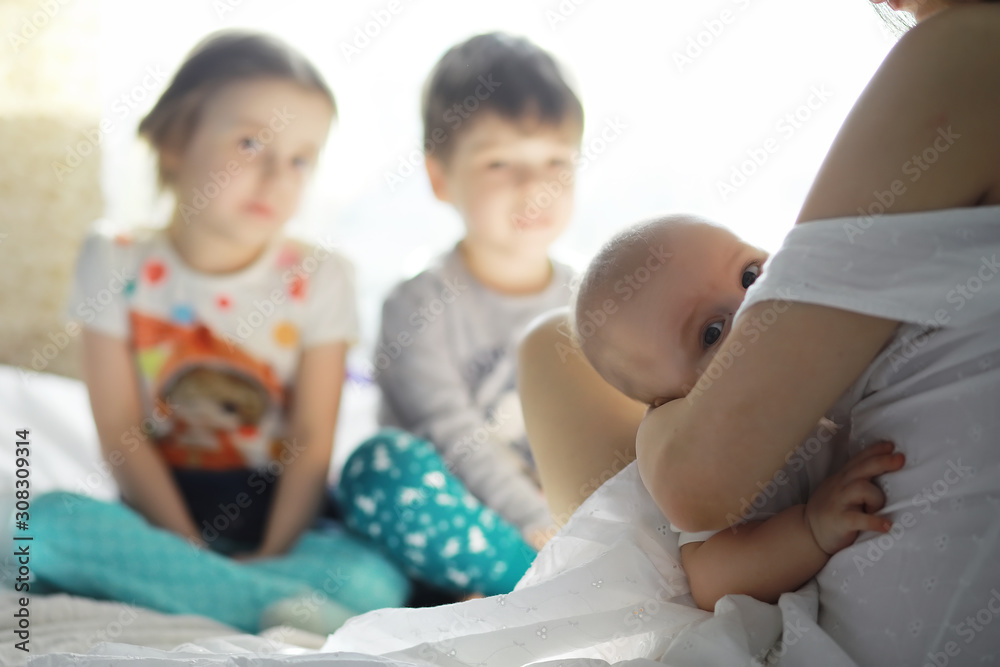 Maternity concept. A young mother feeds her little baby. First lure and breastfeeding. Family in white clothes. Maternity concept. A young mother feeds her little baby. First lure and breastfeeding. Family in white clothes.