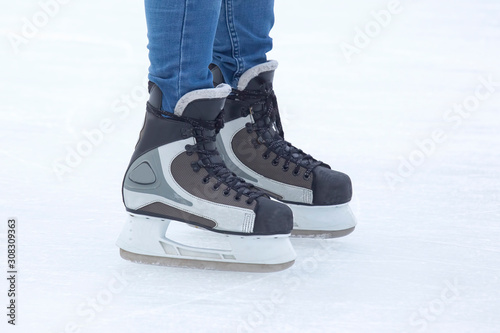 legs in skates actively skates on an ice rink close-up. Hobbies and sports. Vacations and winter activities.