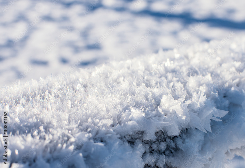 The surface is covered with frozen snowflakes, up-close.