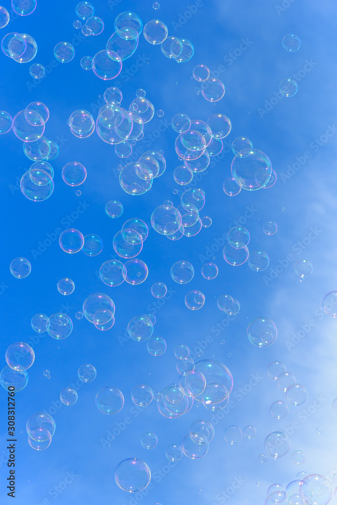 Soap bubbles against blurred blue sky background