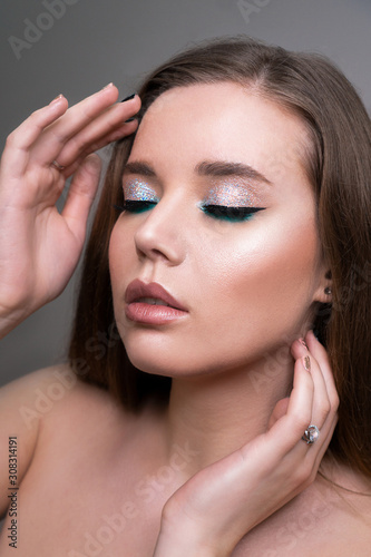Close up of fashion model young woman in trendy make-up. Eye models with colorful glitter on the eyelids