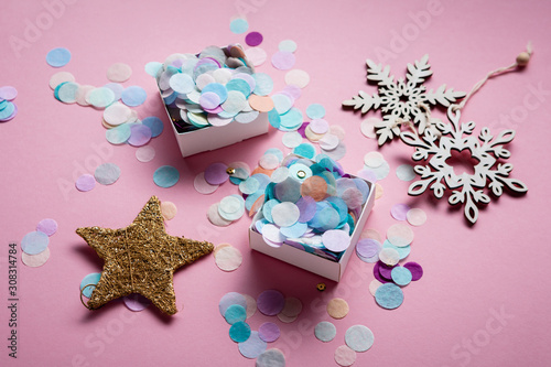 Pink background with christmas decorations and colourful confetti © Olha Afanasieva