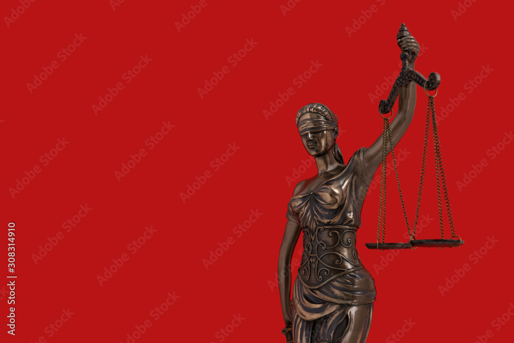 Lady Justice statue is the Greek ancient goddess Themis a symbol of justice isolated on red