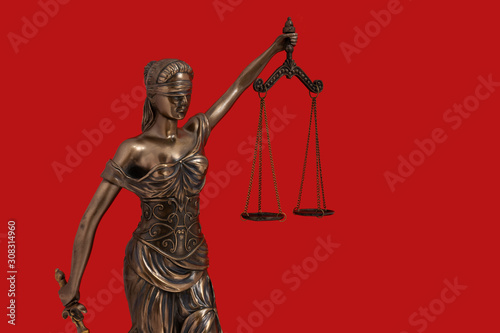 Lady Justice statue is the Greek ancient goddess Themis a symbol of justice isolated on red