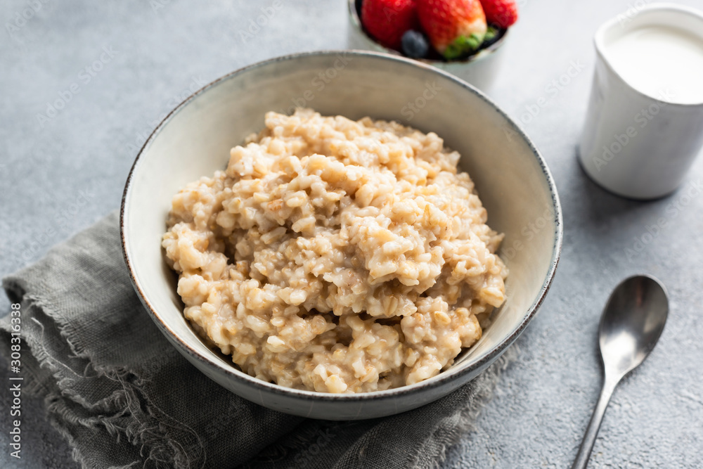 Oatmeal porridge, cooked steel cut oats in bowl. Healthy breakfast, clean eating, well being concept Oatmeal porridge, cooked steel cut oats in bowl. Healthy breakfast, clean eating, well being concept