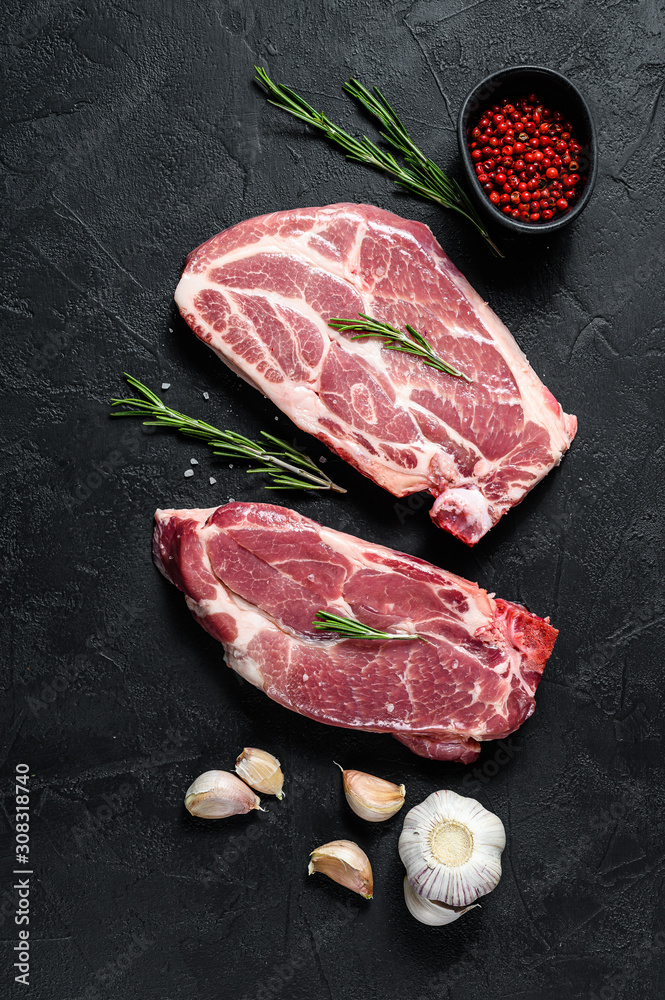 Raw pork steak on the bone. Grilled meat. Black background. Top view