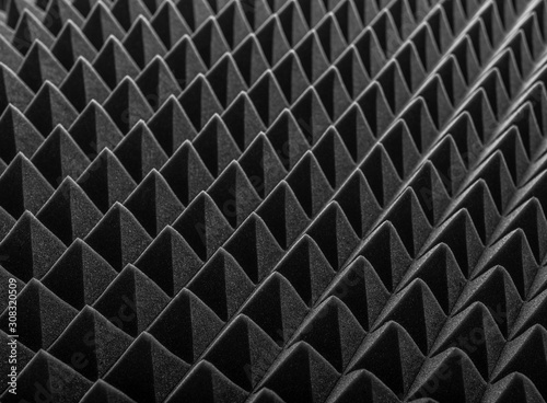 Abstract background in the form of pyramids and dragon scales. Acoustic black foam rubber.