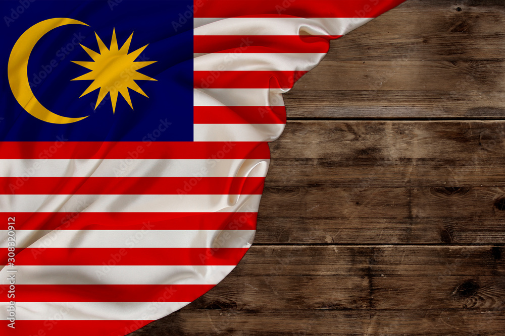 Obraz premium national flag of the modern state of Malaysia, beautiful silk, old wood background, concept of tourism, economy, politics, emigration, independence day, copy space, template, horizontal
