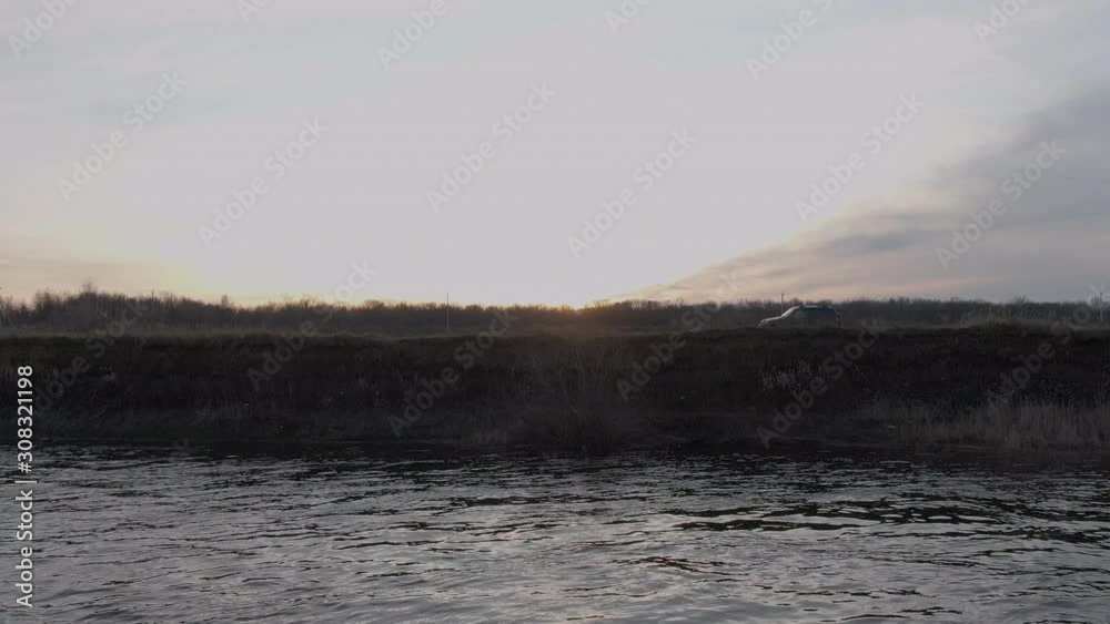 Off road car moving on sea shore on golden sunset landscape. Suv car riding on coast along sea water on evening sunshine. Car travel to sea beach aerial view from drone. Off road car moving on sea shore on golden sunset landscape. Suv car riding on coast along sea water on evening sunshine. Car travel to sea beach aerial view from drone.