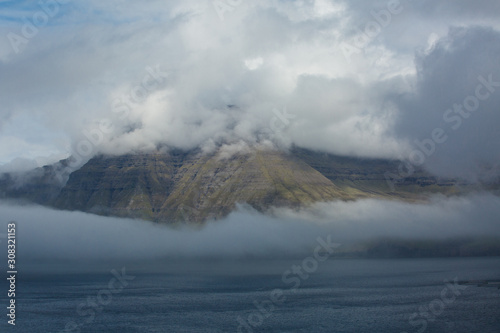 Fototapeta Naklejka Na Ścianę i Meble -  Clouds surrounding hills and mountains in the Faroe Islands