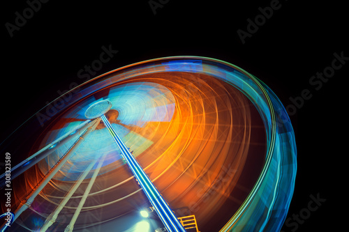 Moving and illuminated ferris wheel, big  wheel on a dark background.