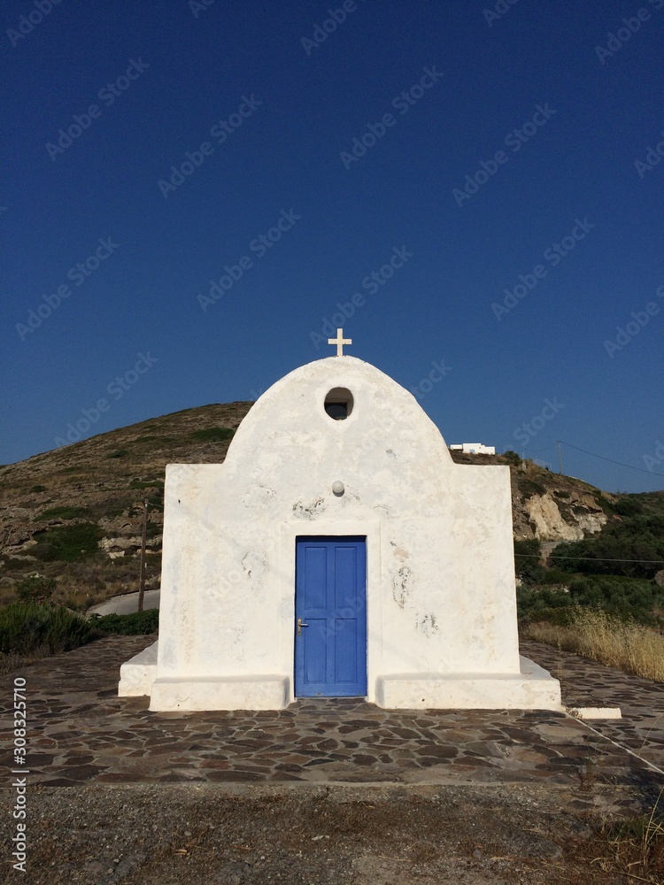 White building with blue door in Milos, Greece White building with blue door in Milos, Greece