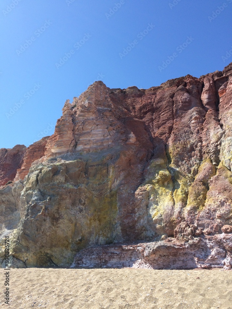 Volcanic red and yellow cliff rocks in Milos, Greece