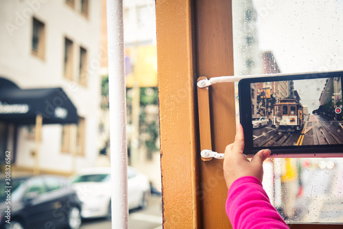 Canvas Print Taking picture of oncoming cable car with tablet