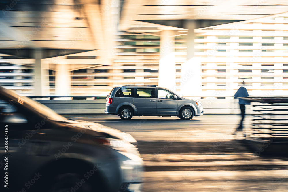 Minivan car driving fast on the street with motion blur