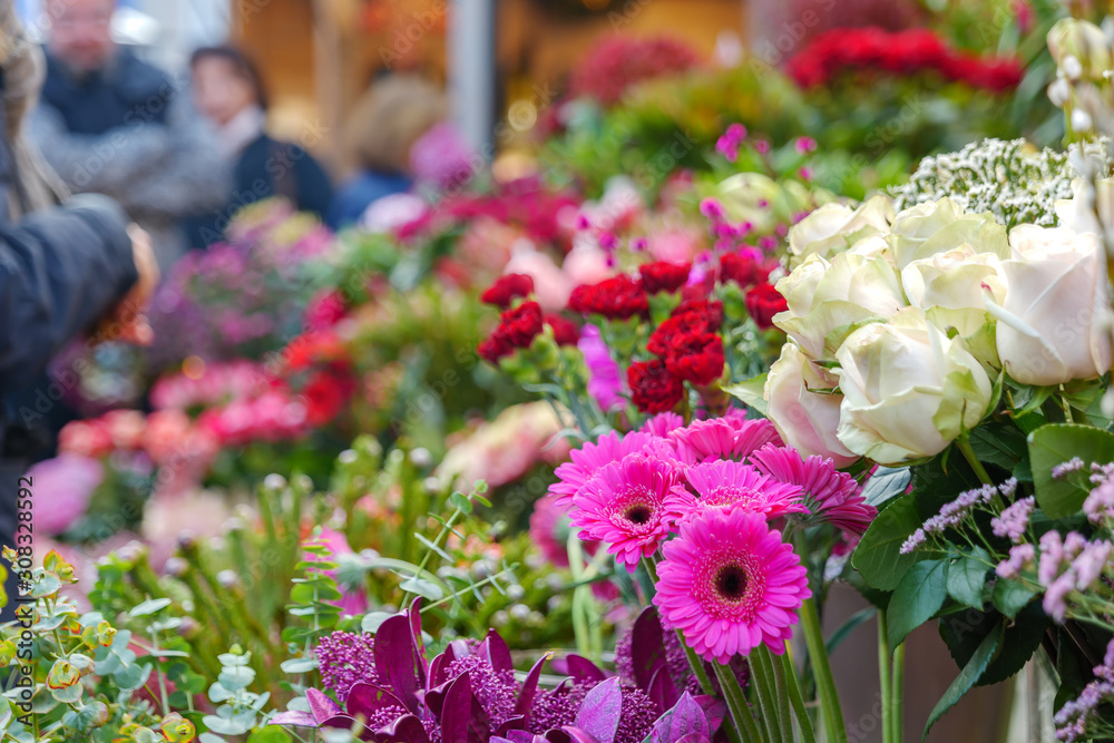 Close up view of colourful various flowers are sold at corridor in front of flower stall or floral shop is located in outdoor market in Europe. Typical atmosphere of flower store at farmer market.   