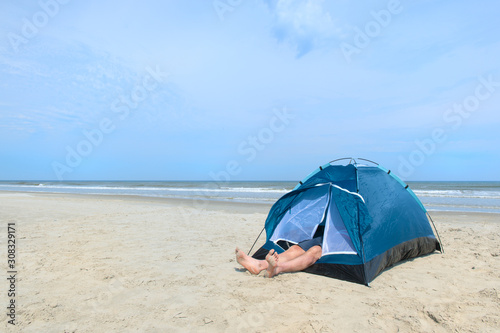 Man camping in shelter at the beach
