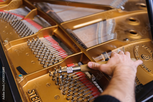 Foto Man tuning traditional upright piano for jazz