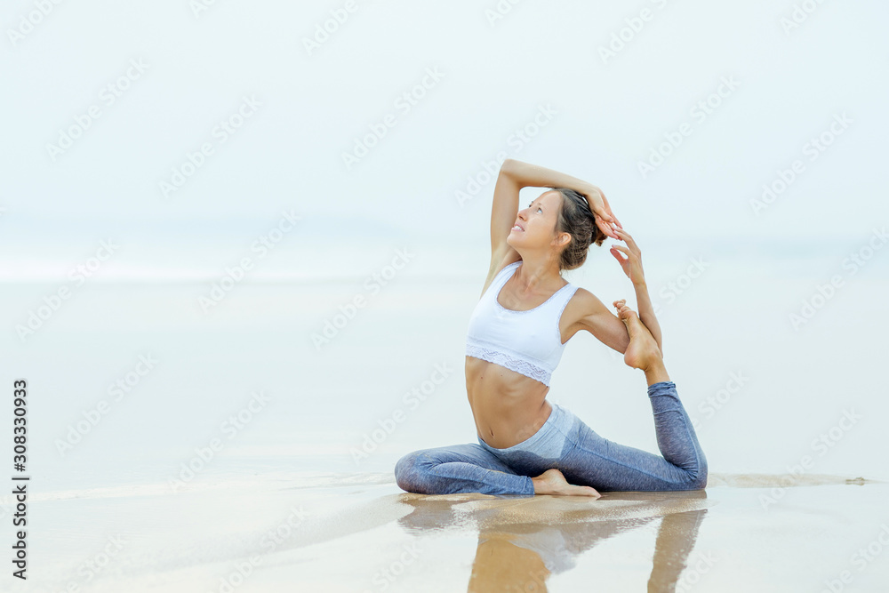 Caucasian woman practicing yoga at seashore Caucasian woman practicing yoga at seashore