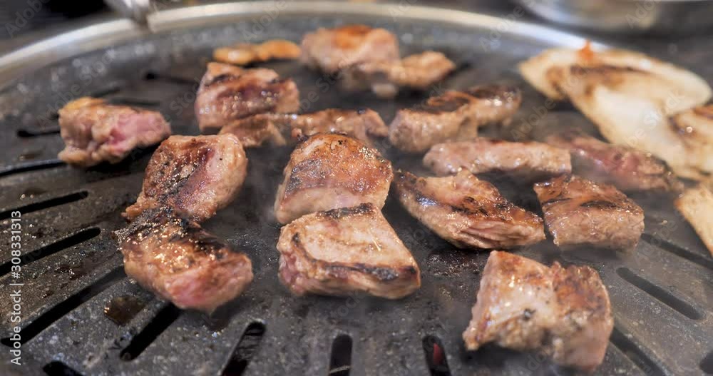 Beef sizzling on a Korean barbecue grill. Beef sizzling on a Korean barbecue grill.