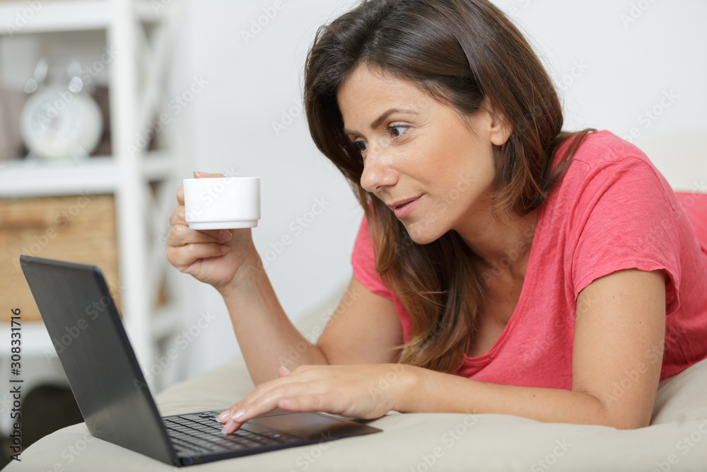 woman with laptop and coffee in bed woman with laptop and coffee in bed