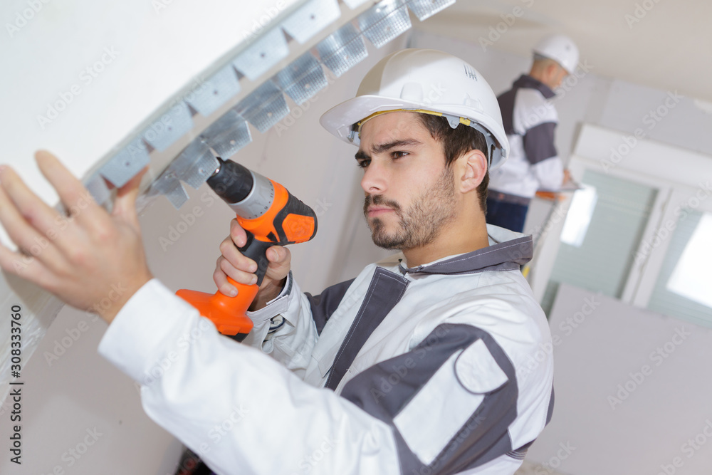 builder drilling into wall builder drilling into wall