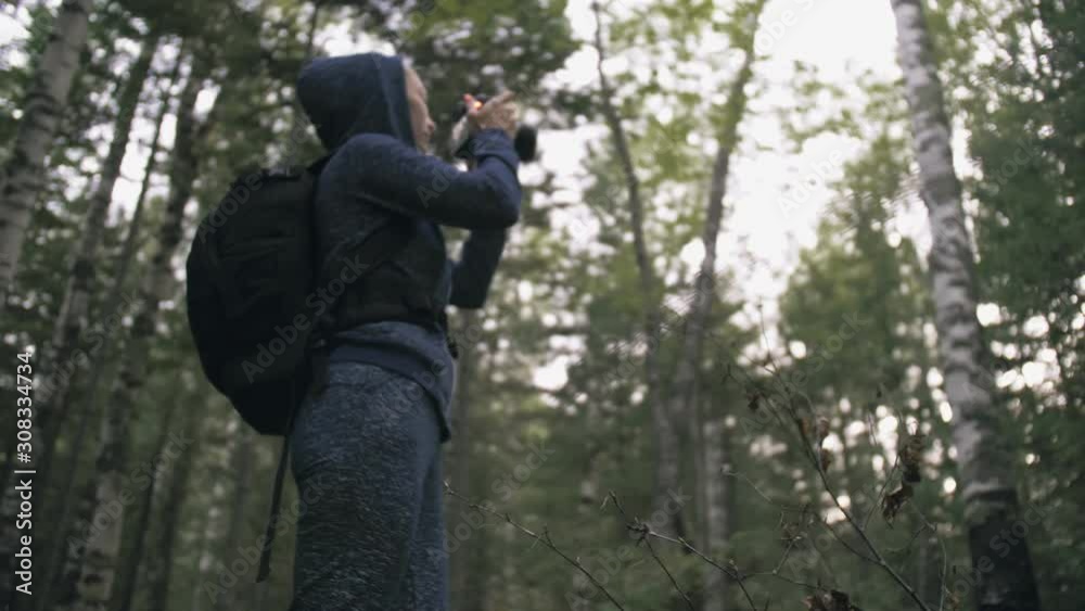 Traveler photographing scenic view in forest. One caucasian woman shooting nice magic look. Girl take photo video on dslr mirrorless camera. Professional photographer travel with backpack. Outdoor. Traveler photographing scenic view in forest. One caucasian woman shooting nice magic look. Girl take photo video on dslr mirrorless camera. Professional photographer travel with backpack. Outdoor.