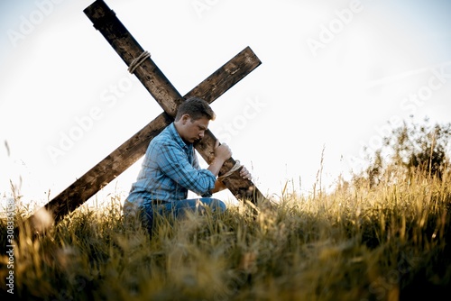 Quadro su tela Shallow focus shot of a male carrying a handmade cross