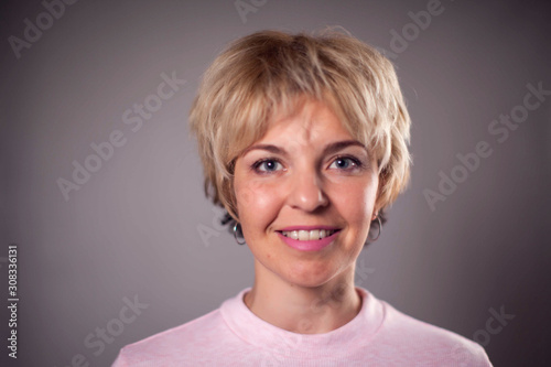 A portrait of a smiling woman with blond hair. People and emotions concept