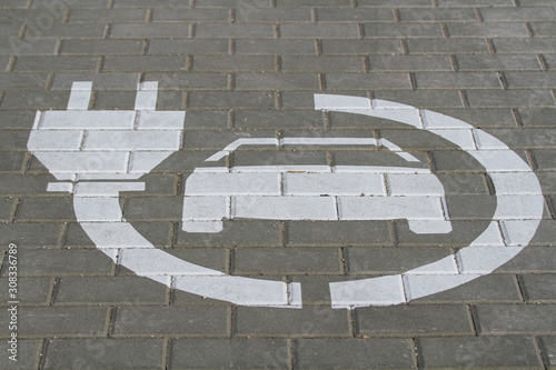 White electric car charging station sign on the road. Concept of ecological electric transport.