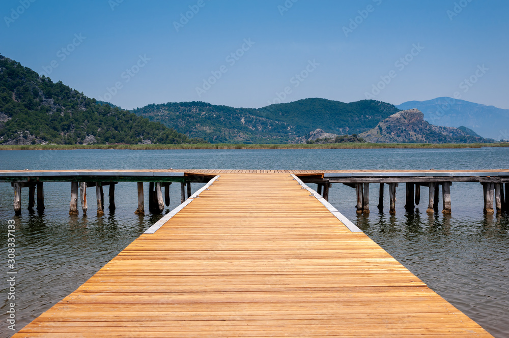 Obraz premium Platform, deck to Dalyan River in Valley of Ancient Rocks Tombs surrouded by mountains in Turkey.