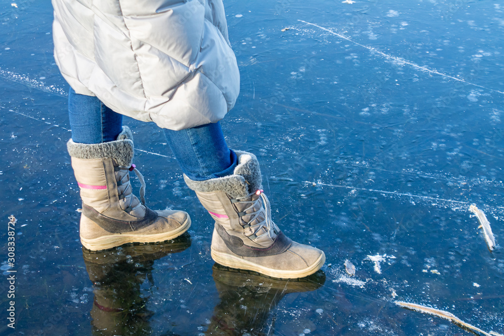 feet on frozen ice, frozen river, thick ice, woman standing on ice foto de  Stock | Adobe Stock