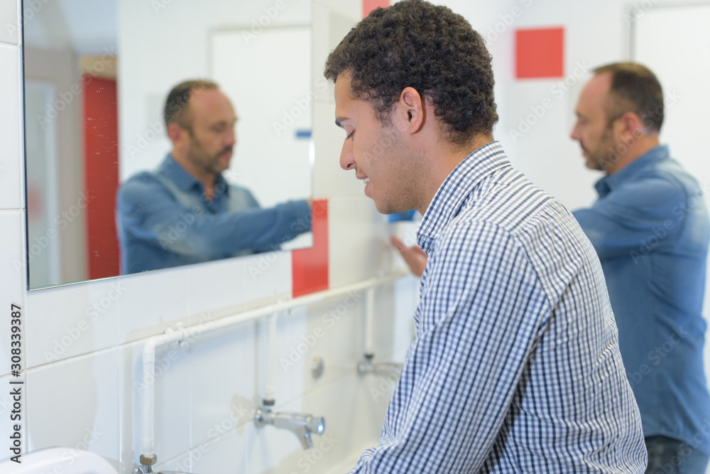 man washing hands in public toilet man washing hands in public toilet