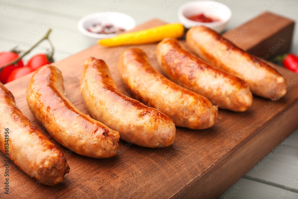 Tasty grilled sausages wooden board, closeup Tasty grilled sausages wooden board, closeup