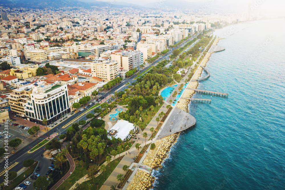 Limassol, Cyprus, aerial view at promenade or embankment. Famous Limassol walking alley with palms and wooden piers in resort town, drone photo.