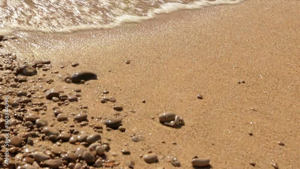 Close Up Of Waves Rolling Up Sandy Beach With Pebbles Close Up Of Waves Rolling Up Sandy Beach With Pebbles