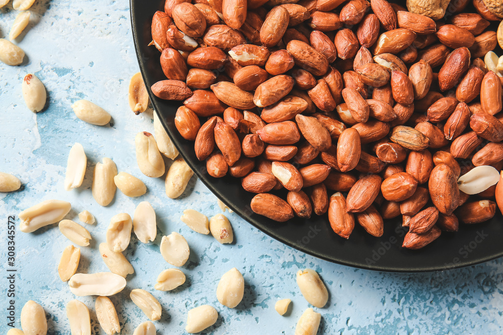 Plate with peanuts on color background Plate with peanuts on color background