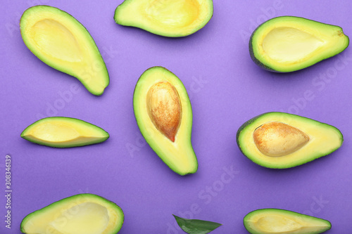 Ripe cut avocados on color background