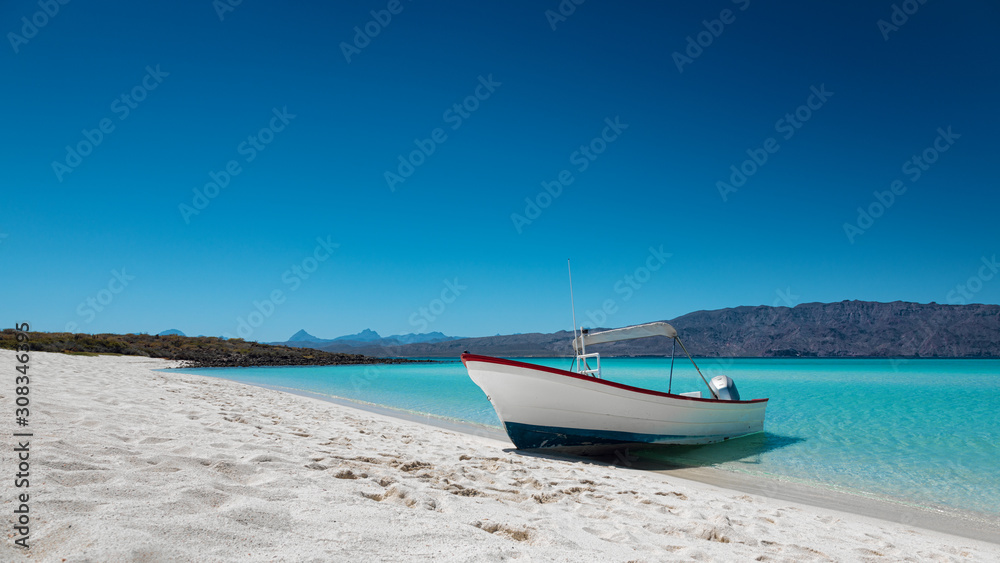 Motor boat at the paradise beach with white sand, turquoise sea and blue sky, Playa Isla Coronado, Mexico