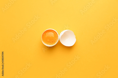 Broken raw egg on color background