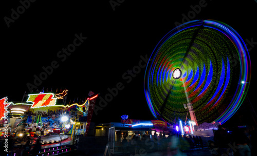 Ferris wheel in motion in the amusement park, at night. Long exposure photography. 