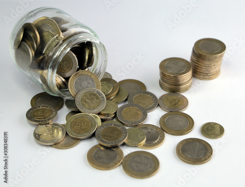 Rising coins, magnifying glass, Pile of mixed iron money coins background