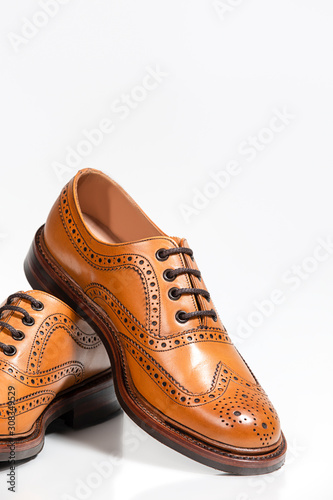 Footwear Concepts. Full Broggued Tan Leather Oxfords Shoes Isolated On White Background.