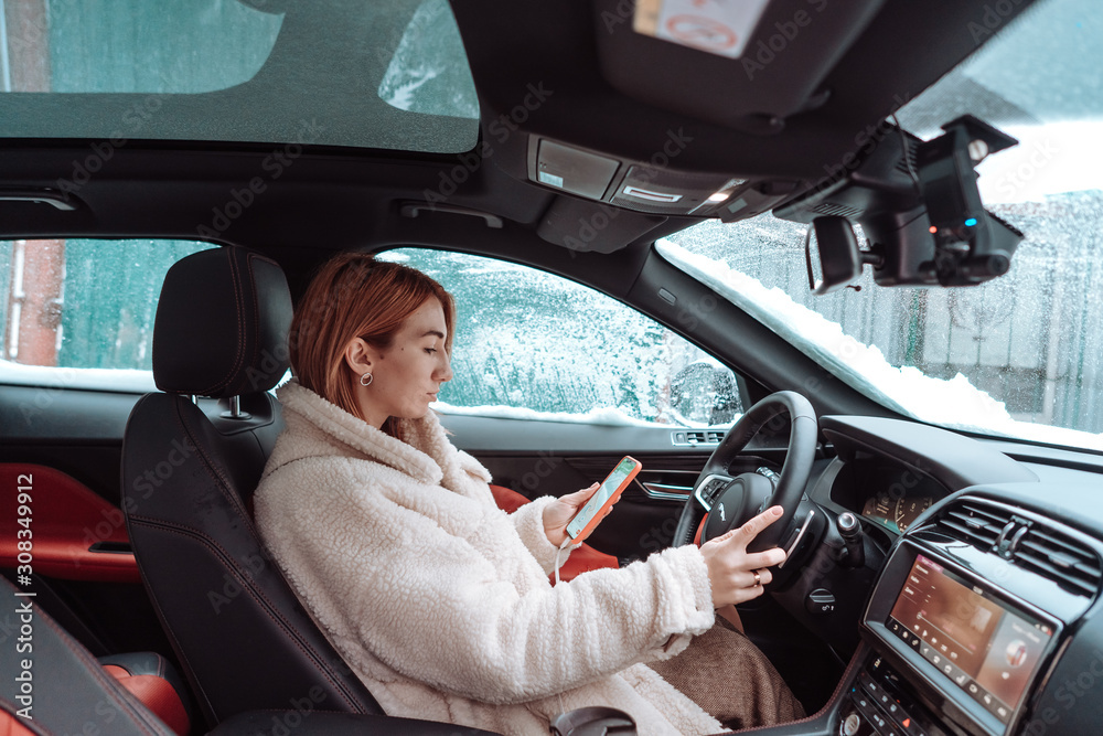 Attractive woman driver nsitting behind the steering wheel in her car Attractive woman driver nsitting behind the steering wheel in her car